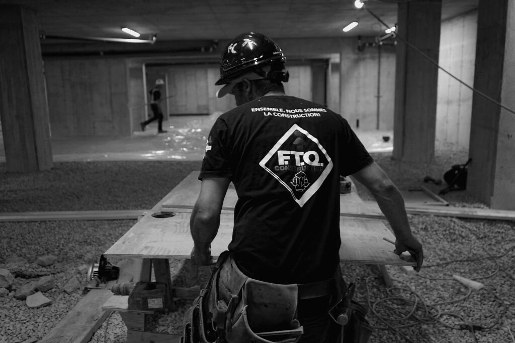 Homme sur un chantier de construction portant le chandail FTQ construction